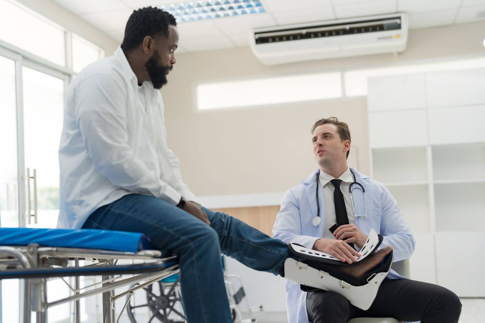 Provider evaluating a patient's knee in a bright Upper Manhattan clinic